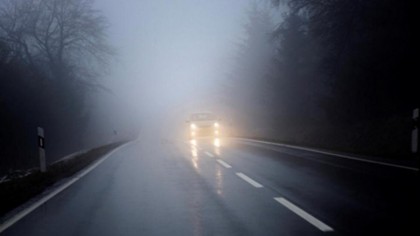 Coche a través de una carretera con niebla